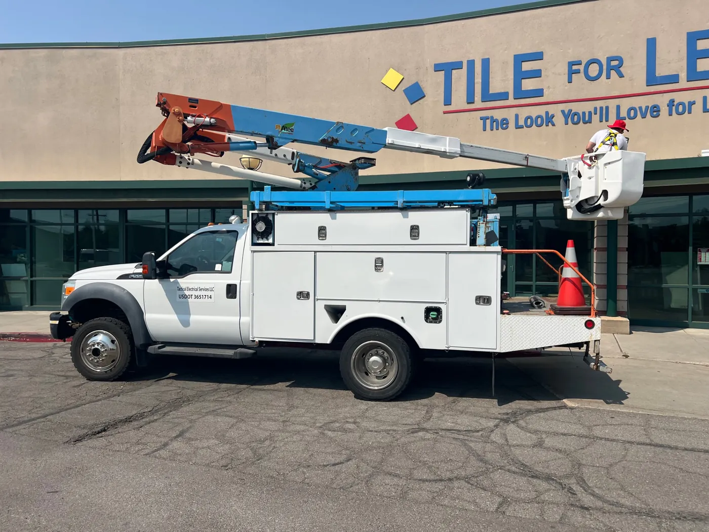 Tactical Electrical Services bucket truck parked at a commercial retail building