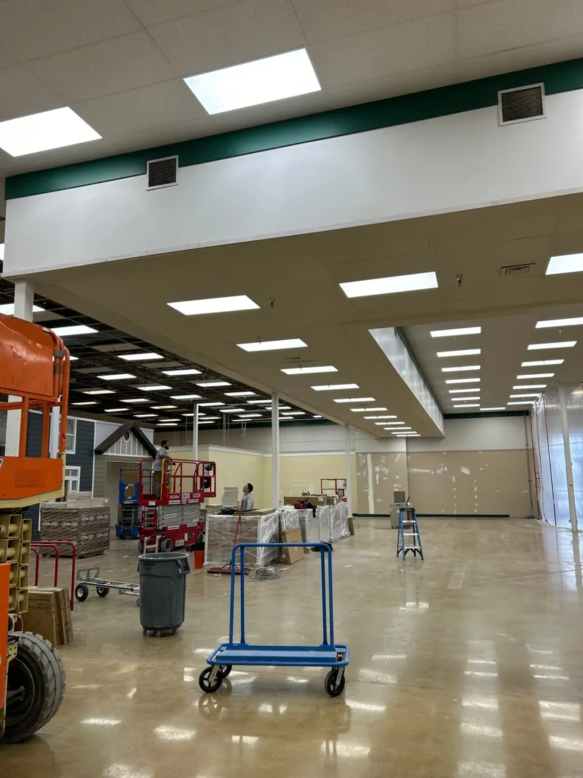Retail store LED flat panel lighting installed from a scissor lift