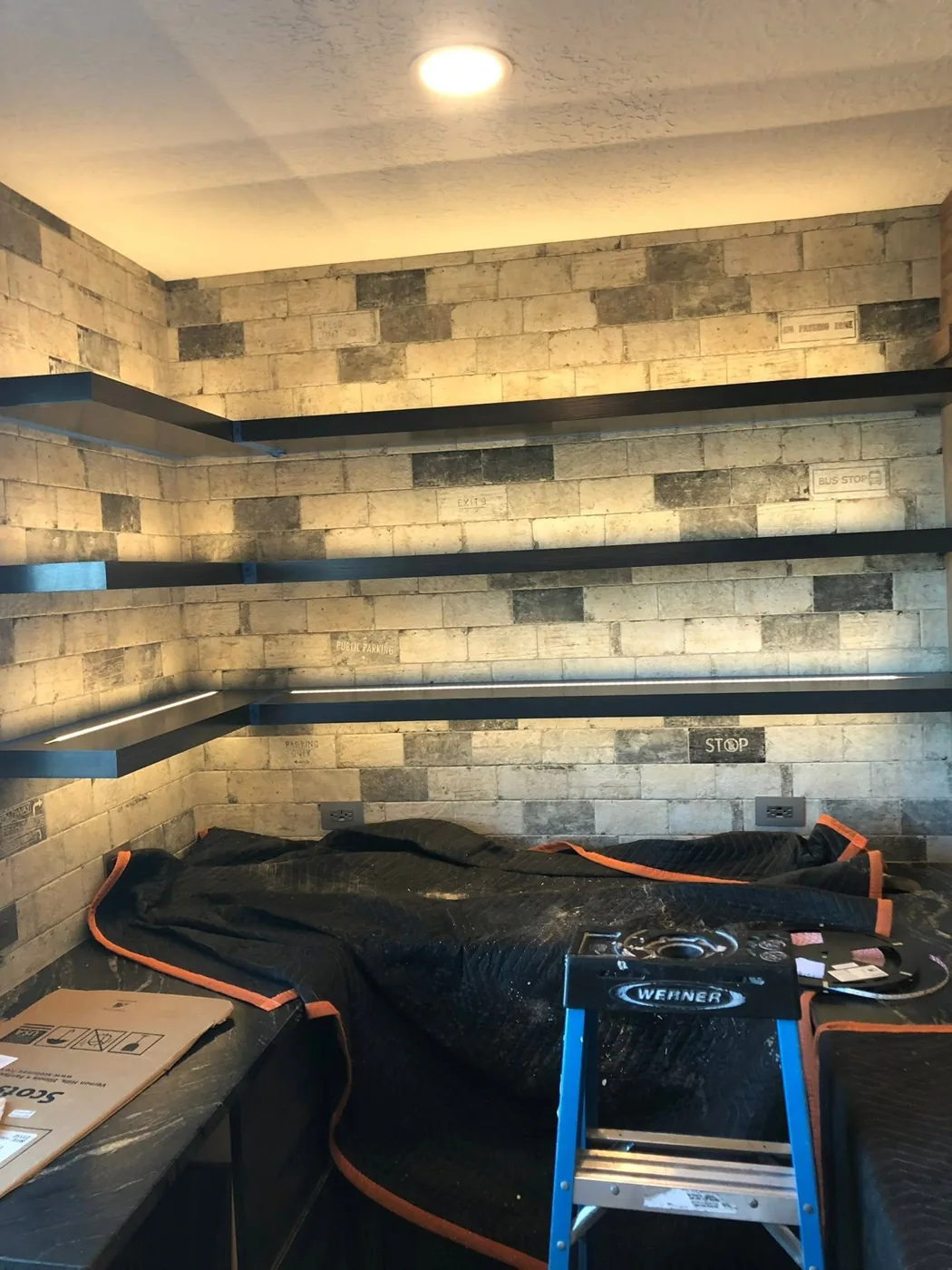 Stone accent wall with linear cove lighting installed by Tactical Electrical Services