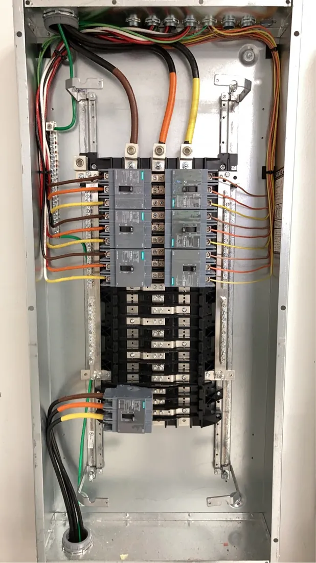 Interior of a newly installed panel with neatly landed breakers and conductors